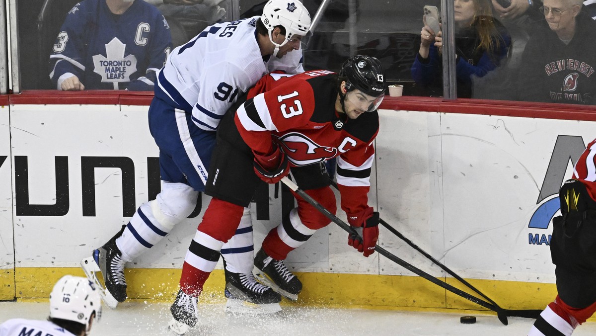 Toronto Maple Leafs center John Tavares (91) checks New Jersey Devils center Nico Hischier (13) during the third period of an NHL hockey game Tuesday, April 9, 2024, in Newark, N.J. The Maple Leafs wo ...
