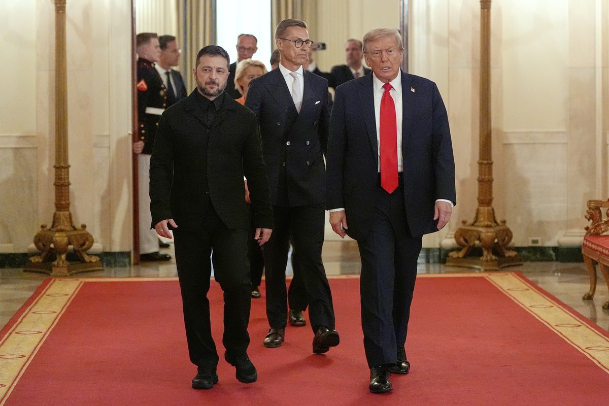 Ukraine's President Volodymyr Zelenskyy, from left, Finland's President Alexander Stubb and President Donald Trump walk through the Cross Hall of the White House, Monday, Aug. 18, 2025, in W ...