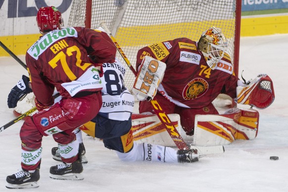 Tigers Samuel Erni, links, und Goalie Ivars Punnenovs, rechts, kaempfen um den Puck gegen Zugs Sven Senteler, Mitte, waehrend des Eishockey Meisterschaftsspiels der National League zwischen den SCL Ti ...