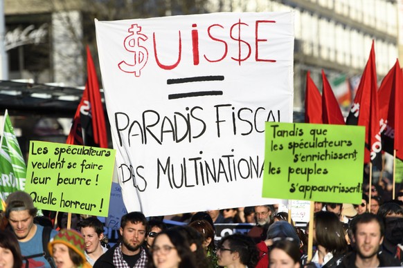 epa05874093 Participants with a banner &#039;Switzerland - An international fiscal paradise&#039; take part in a demonstration to protest against the Financial Times Commodities Global Summit in Lausa ...