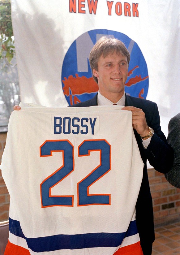 FILE - Mike Bossy holds his New York Islanders uniform up at a news conference in New York, Oct. 24, 1988. Bossy, one of hockey