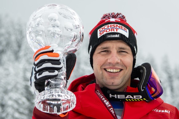Beat Feuz of Switzerland poses with the crystal globe of the overall men&#039;s Downhill competition after the podium ceremony at the FIS Alpine Skiing World Cup finals, in Parpan-Lenzerheide, Switzer ...
