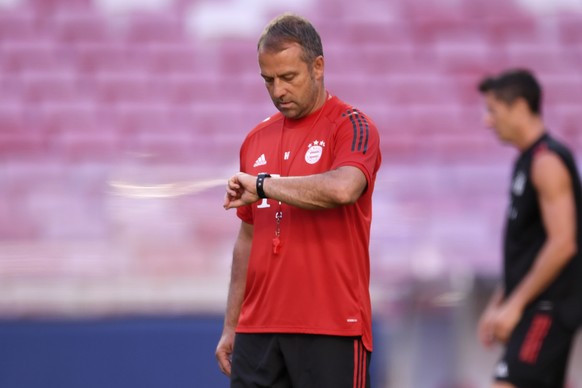 Bayern&#039;s coach Hans-Dieter Flick checks his watch during a training session at the Luz stadium in Lisbon, Saturday Aug. 22, 2020. Bayern Munich will play PSG in the Champions League final soccer  ...