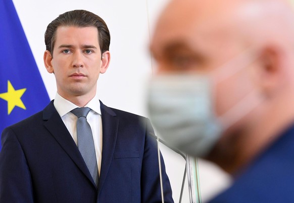 epa08345498 A journalist wearing a face mask is seen next to Austrian Chancellor Sebastian Kurz during a press conference at the Austrian Chancellery in Vienna, Austria, 06 April 2020. Kurz announces  ...