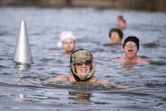 Swimmers swim during the traditional Sylvester swim at lake Moossee in Moosseedorf, Switzerland, Saturday, December 31, 2022. The lake currently has a temperature between 5 and 6 degrees Celsius. (KEY ...
