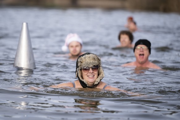 Swimmers swim during the traditional Sylvester swim at lake Moossee in Moosseedorf, Switzerland, Saturday, December 31, 2022. The lake currently has a temperature between 5 and 6 degrees Celsius. (KEY ...