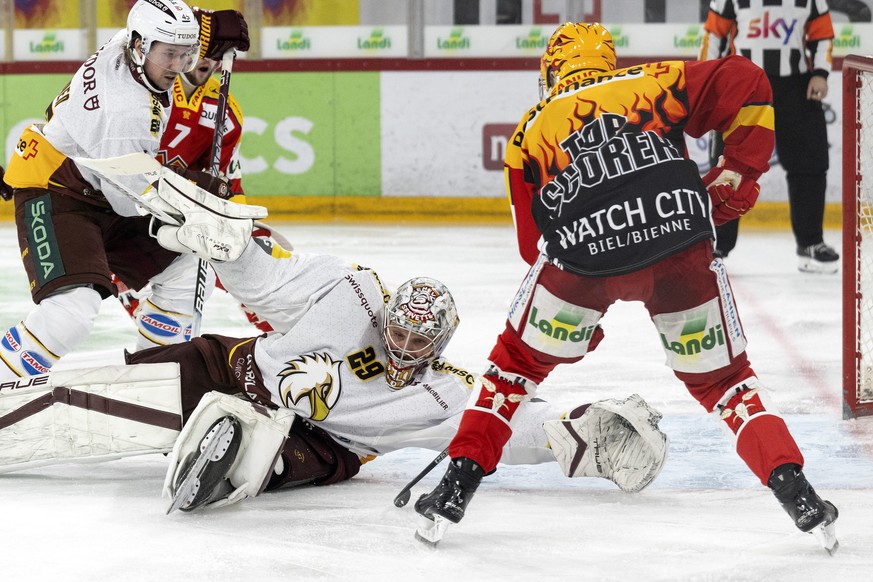 Biels PostFinance Top Scorer Toni Rajala, rechts, im Duell mit Genfs Torhueter Robert Mayer im zweiten Eishockey Play In Spiel der National League zwischen dem EHC Biel und Genf Servette HC, am Samsta ...