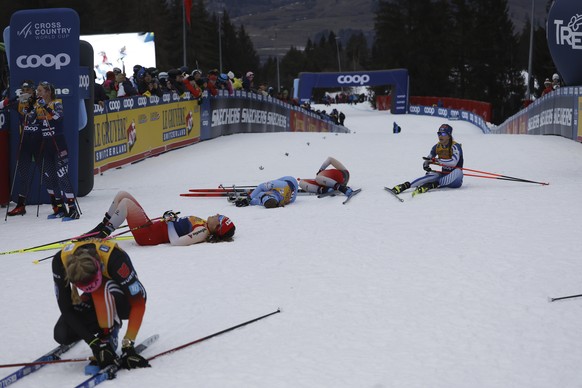 Exhausted athletes at the arrival of the 10km women's mass start race of the Tour de Ski cross country, in Val di Fiemme, Italy, Sunday, Jan. 5, 2025. (AP Photo/Alessandro Trovati)
