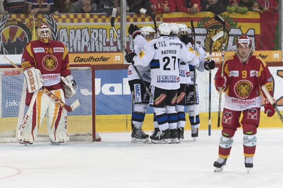 Tigers Goalie Ivars Punnenovs, links, und Lukas Haas, rechts, sind geschlagen, Fribourgs Spieler, Mitte jubeln, waehrend dem Meisterschaftsspiel der National League, zwischen den SCL Tigers und dem HC ...