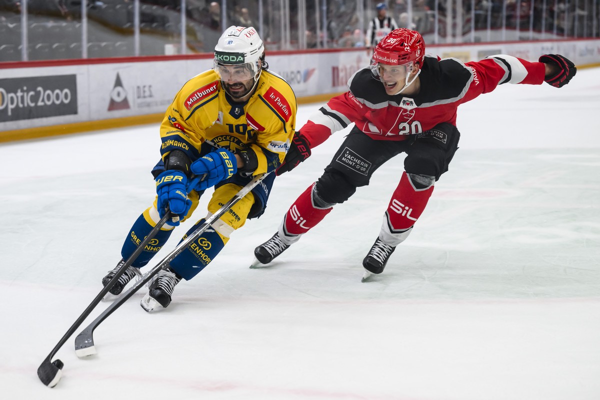 L'attaquant davosien Andres Ambuehl, gauche, lutte pour le puck avec le defenseur lausannois Lawrence Pilut, droite, lors du match du championnat suisse de hockey sur glace de National League ent ...