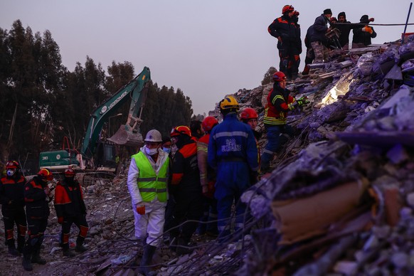 epa10467147 Rescuers work at the site of collapsed buildings after a powerful earthquake, in Hatay, Turkey, 14 February 2023. More than 37,000 people died and thousands more were injured after two maj ...