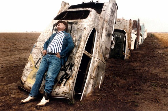 FILE - In this June 1984 file photo, Stanley Marsh 3 leans on one of the 10 Cadillacs buried down on his ranch west of Amarillo, Texas, along old Route 66. Stanley Marsh 3, whose partially buried row  ...
