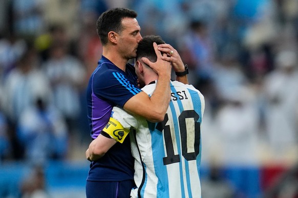 FILE - Argentina's head coach Lionel Scaloni kisses Argentina's Lionel Messi, right, at the end of the World Cup quarterfinal soccer match between the Netherlands and Argentina, at the Lusai ...