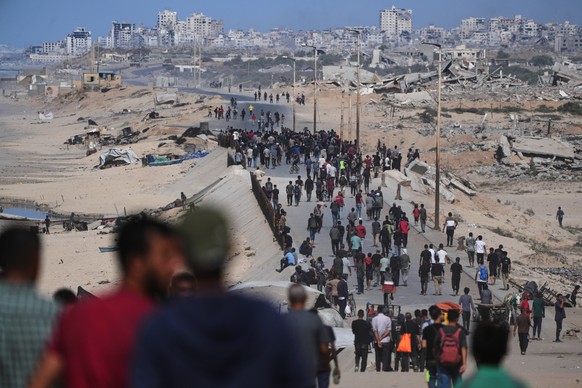 Displaced Palestinians gather on the coastal road near Wadi Gaza after the announcement that Israel and Hamas had agreed to the first phase of a peace plan to pause the fighting, as Israeli tanks bloc ...