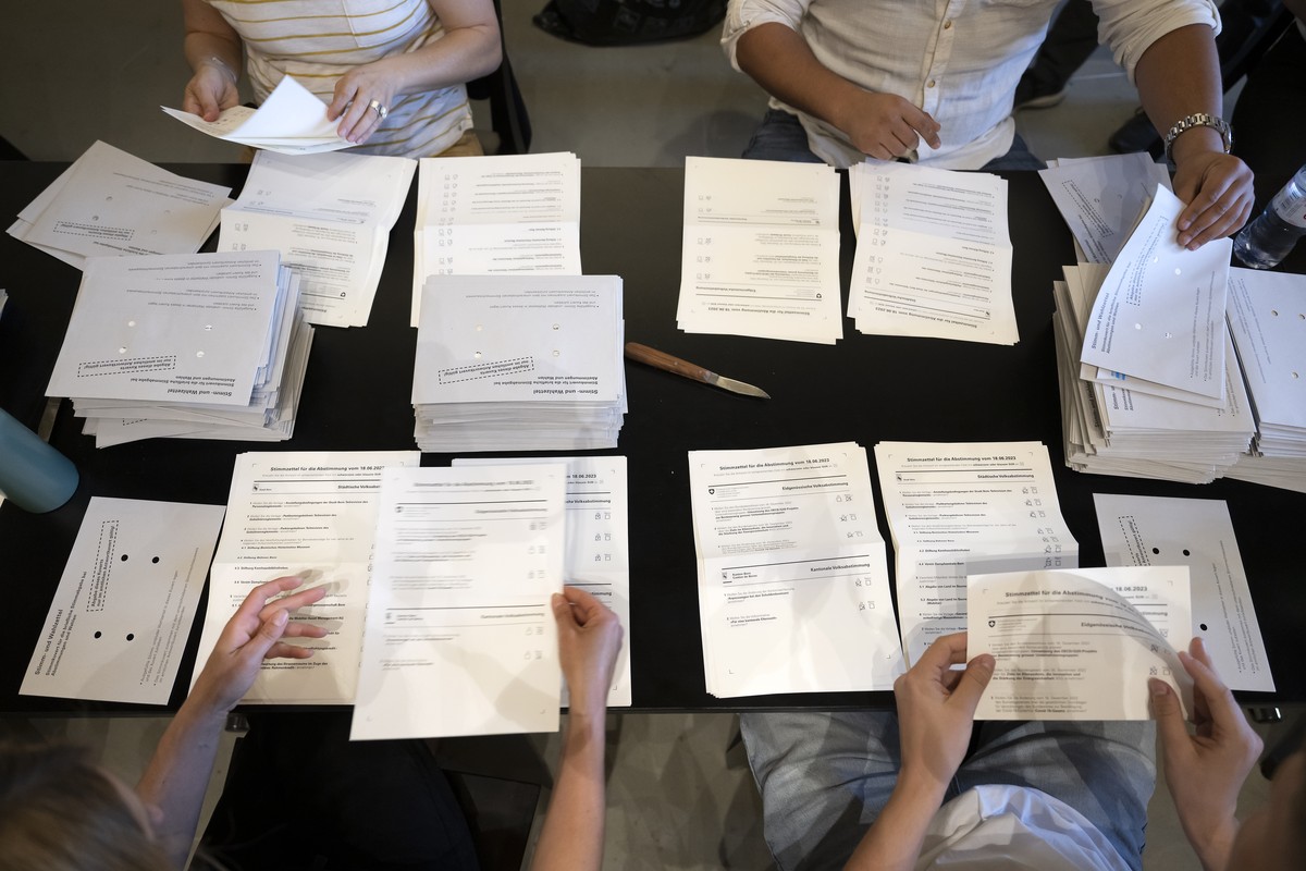 Abstimmungshelferinnen und Abstimmungshelfer sortieren die Abstimmungszettel der Eidgenoessischen Volksabstimmungen und der Staedtischen Volksabstimmungen und der Kantonalen Volksabstimmungen, am Vora ...