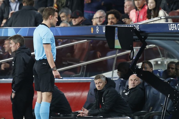 Manchester United coach Ole Gunnar Solskjaer, bottom, watches German referee Felix Brych as watching the VAR monitor during the Champions League quarterfinal, second leg, soccer match between FC Barce ...
