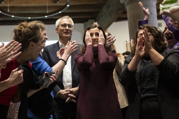 epa10934387 SP State Council candidate Flavia Wasserfallen (C) reacts next to Green Party candidate Bernhard Pulver as the results of the first round of voting are announced, along with SP National Co ...