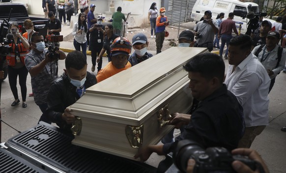 People place a coffin containing the remains of a female inmate into a hearse in Tegucigalpa, Honduras, Wednesday, June 21, 2023. A riot on Tuesday at a women&#039;s prison northwest of the Honduran c ...