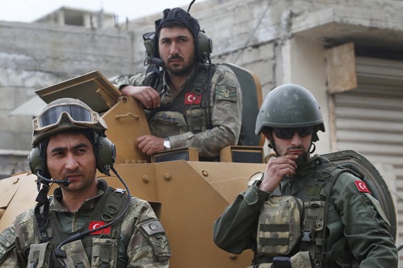 FILE - In this March 24, 2018 file photo, Turkish soldiers atop an armored personnel carrier secure the streets of the northwestern city of Afrin, Syria, during a Turkish government-organized media to ...