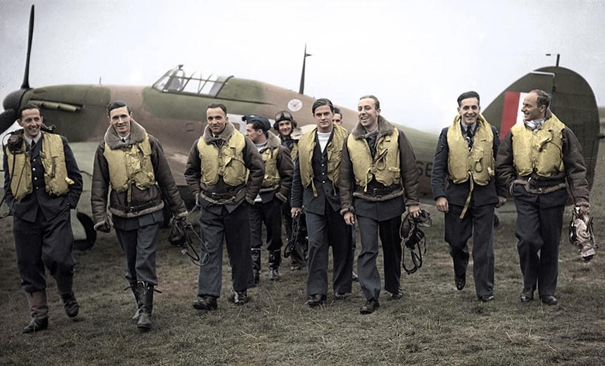 Piloten der 303. Staffel der Royal Air Force. Jan Zumbach steht im Hintergrund und trägt eine Fliegerbrille auf dem Kopf. Koloriertes Foto, um 1940.
https://commons.wikimedia.org/wiki/Category:Jan_Zum ...