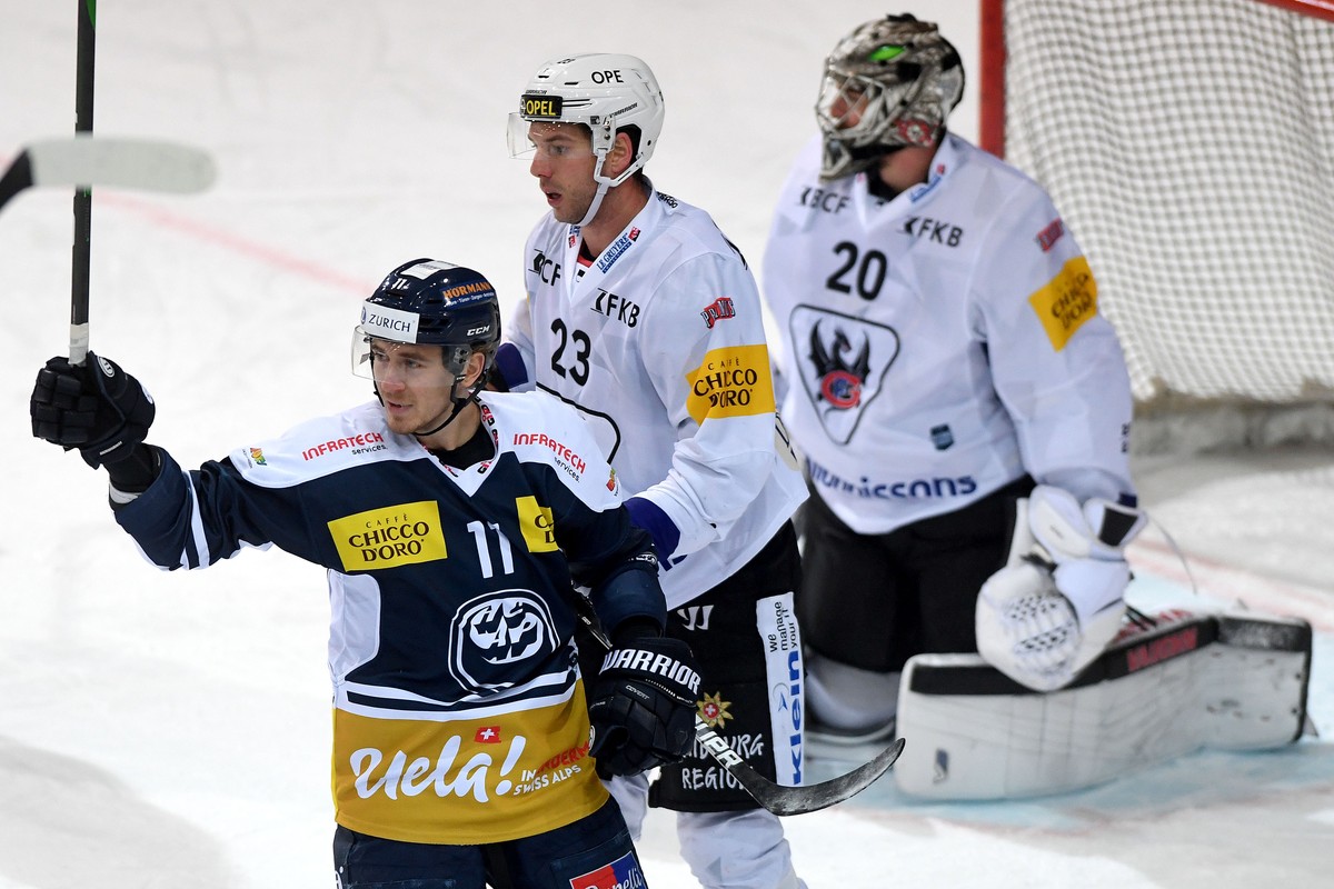 Ambri's player Johnny Kneubuehler, left, celebrates the 3 - 0 goal, during the preliminary round game of National League A (NLA) Swiss Championship 2020/21 between HC Ambri Piotta against Fribour ...