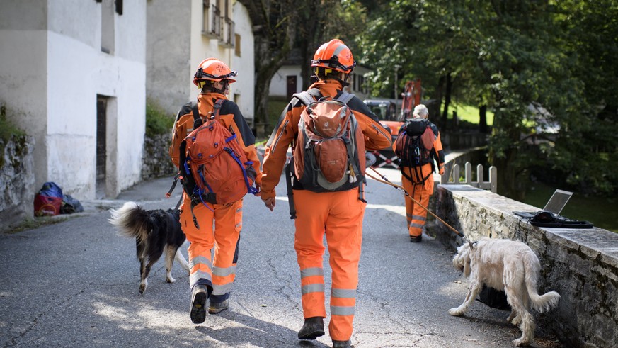 epa06161652 A search-and-rescue team arrives on the improvised heliport in Bondo, Graubuenden in South Switzerland, 25 August 2017. The village had been hit by a massive landslide on Wednesday. The ma ...