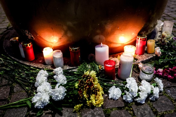 epa12933494 Candles and flowers are placed near the crime scene after at least two people were killed and several others injured when a car drove into a crowd in a pedestrian zone, in Leipzig, Germany ...