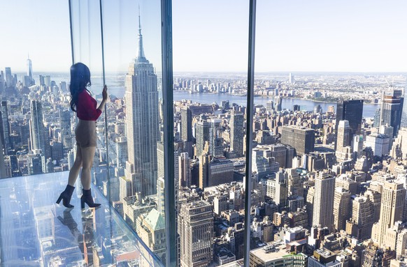 epa09500157 A person looks out while standing in the ?Levitation? space, which features a glass floor and is one of the rooms in the new Summit One Vanderbilt observation deck, being called ?Air by Ke ...