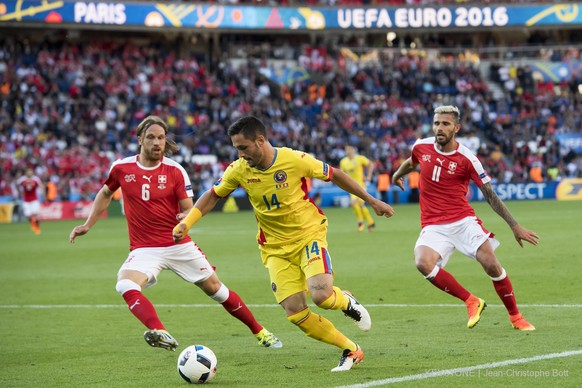 Swiss defender Michael Lang, left, and Swiss midfielder Valon Behrami, right, fight for the ball with RomaniaÕs forward Florin Andone, center, during the UEFA EURO 2016 group A preliminary round socce ...