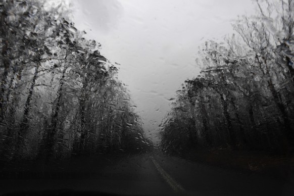 epa08103577 Rain is seen on the windscreen of a vehicle as it falls in an area that was burnt by bushfires the previous day, near Nowra, New South Wales, Australia, 05 January 2020. EPA/DEAN LEWINS AU ...