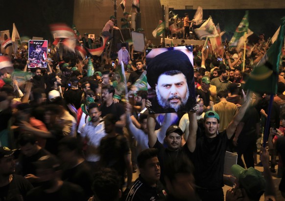 Followers of Shiite cleric Muqtada al-Sadr celebrate holding his posters, after the announcement of the results of the parliamentary elections in Tahrir Square, Baghdad, Iraq, Monday, Oct. 11, 2021. I ...