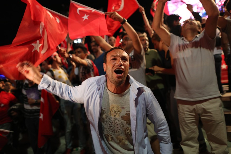 epa05433864 Supporters of Turkish President Recep Tayyip Erdogan shout slogans and hold flags during a demonstration against the 15 July failed coup attempt, at Taksim Square, in Istanbul, Turkey, 20  ...