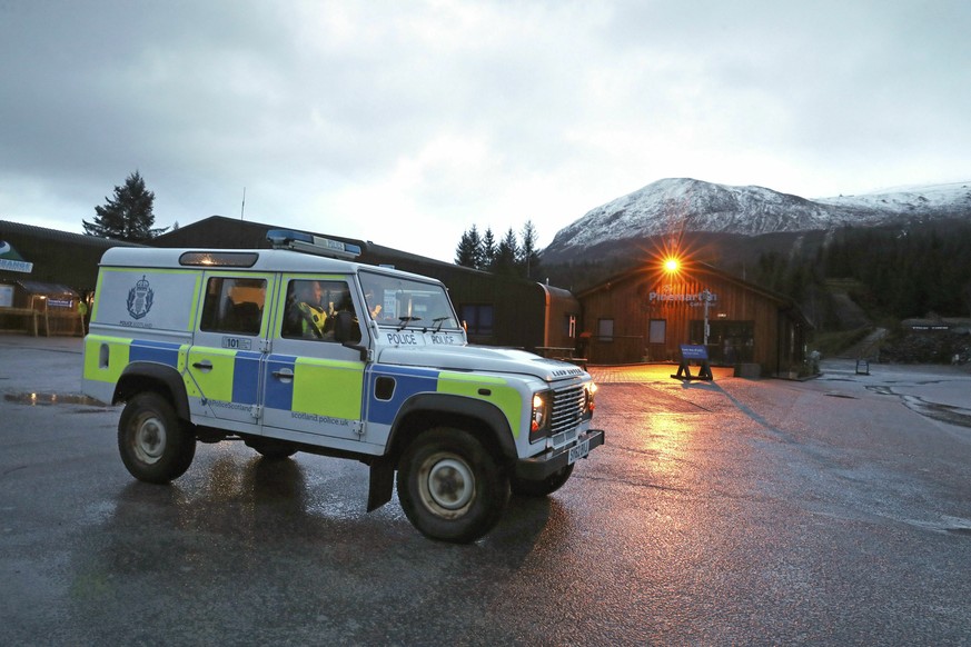 A police vehicle at the Nevis Range Mountain Resort with Ben Nevis in the background, in Scotland, Tuesday March 12, 2019. Police in Scotland say an avalanche has killed two people on Britain&#039;s h ...