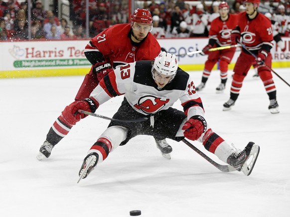 Carolina Hurricanes&#039; Nino Niederreiter (21), of the Czech Republic, and New Jersey Devils&#039; Nico Hischier (13), of Switzerland, chase the puck during the second period of an NHL hockey game i ...