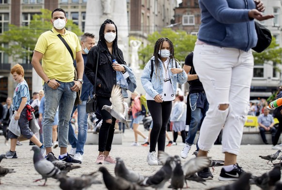 epa08562753 Tourists and day-trippers on Dam Square in Amsterdam, The Netherlands, 23 July 2020. The municipality of Amsterdam is taking extra measures against the crowds and hopes to prevent the furt ...