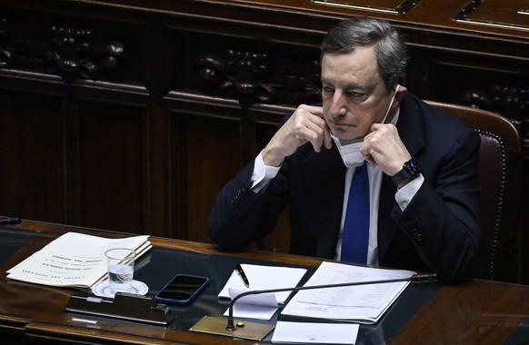 epa09020543 Italian Prime Minister Mario Draghi adjust his face mask as he waits at the lower Chamber of Deputies prior to a confidence vote on his new government, Rome, Italy, 18 February 2021. EPA/R ...