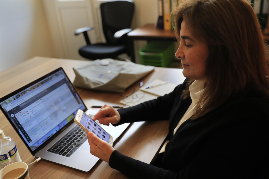 Diana Moukalled, a Lebanese journalist who closely follows social media checks the Clubhouse application, at her office in Beirut, Lebanon, Wednesday, April 7, 2021. Hundreds of thousands of people in ...