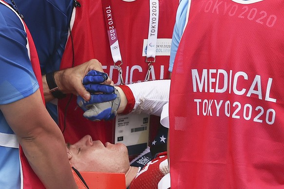 epa09378674 Connor Fields (C) of USA receives medical attention after crashing at the Men&#039;s Cycling BMX Racing semifinal during the Cycling BMX Racing events of the Tokyo 2020 Olympic Games at th ...