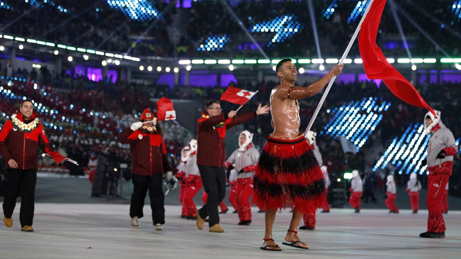 Pita Taufatofua carries the flag of Tonga during the opening ceremony of the 2018 Winter Olympics in Pyeongchang, South Korea, Friday, Feb. 9, 2018. (AP Photo/Jae C. Hong)