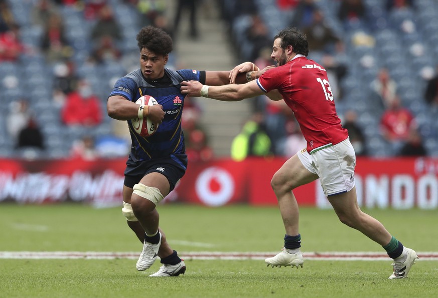 Japan&#039;s Tevita Tatafu, left, avoids a tackle by British and Irish Lions&#039; Robbie Henshaw during a friendly rugby match between British and Irish Lions and Japan at the Murrayfield stadium in  ...