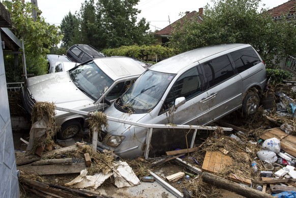 epa05461020 Damaged vehicles in a street in the village of Stajkovci, Skopje, The Former Yugoslav Republic of Macedonia on 07 August 2016. At least 15 people have died in a rain storm that hit the Mac ...