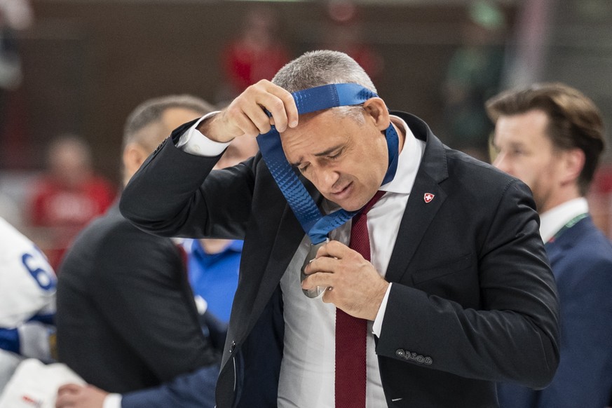 epa13007630 Switzerland's head coach Jan Cadieux looks disappointed as he takes off the silver medal after losing the 2026 IIHF Men's Ice Hockey World Championship gold medal game between Sw ...
