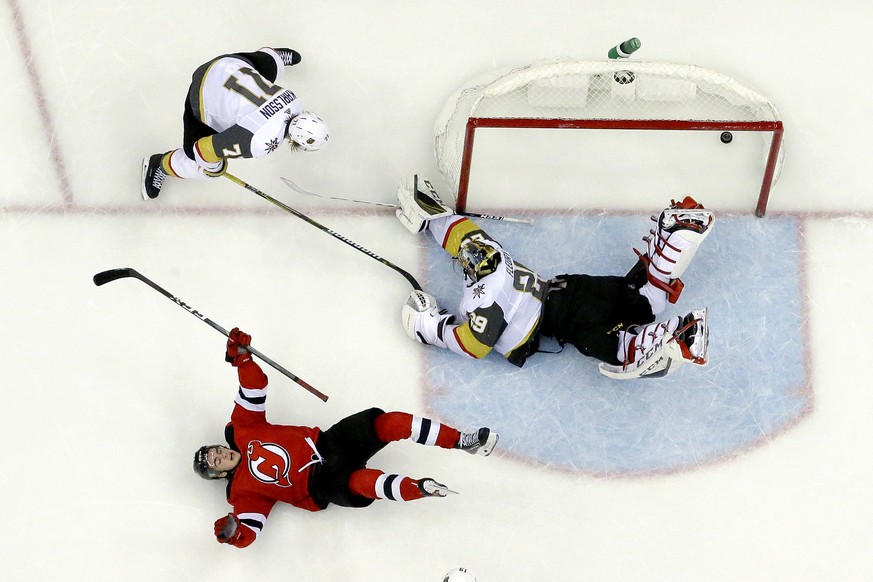 New Jersey Devils center Nico Hischier, bottom left, of Switzerland, celebrates after scoring the winning goal against Vegas Golden Knights goaltender Marc-Andre Fleury, right, during overtime of an N ...