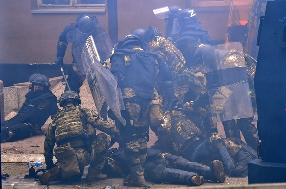epa10662250 Soldiers of NATO-led international peacekeeping Kosovo Force (KFOR) lie injured after a scuffle with ethnic Serbs in front of the building of the municipality in Zvecan, Kosovo, 29 May 202 ...