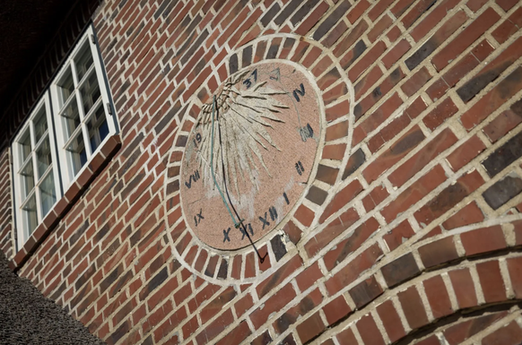 Eine Sonnenuhr an der Aussenwand des Hauses.