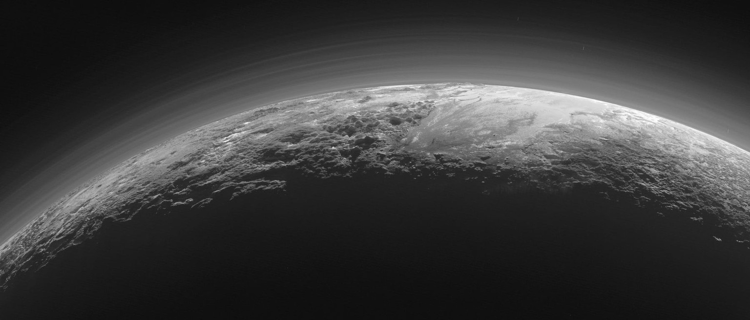 After traveling more than 9 years and covering 3 billion miles, the New Horizons spacecraft was rewarded with this breathtaking view of distant Pluto glowing with a majestic, layered atmosphere agains ...