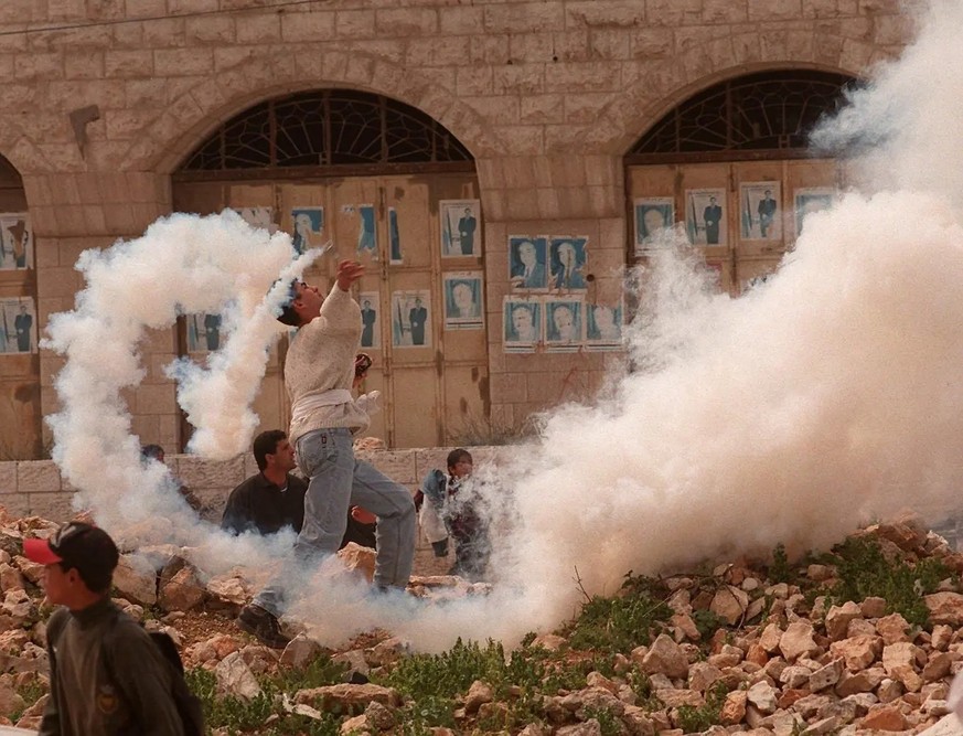 20. März 1997: Ein junger Palästinenser wirft einen Tränengaskanister zurück auf israelische Soldaten.