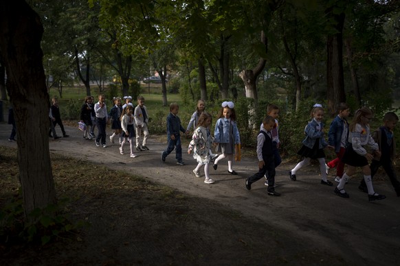 Students walk together entering in their class during their first day of school at a public school in Irpin, Ukraine, Thursday, Sept. 1, 2022. Ukrainian children return to school without sharing memor ...