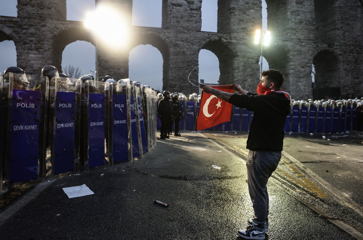 epa11984016 A masked protester confronts Turkish riot police as demonstrators try to march to Taksim Square from the Istanbul Municipality headquarters during a protest against the detention of Istanb ...