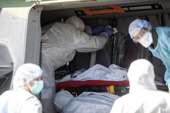 Medical staffs evacuate a patient infected with the Covid-19 virus into a French military helicopter heading to Switzerland to ease the situation in eastern France, Monday, March 30 2020 in Strasbourg ...